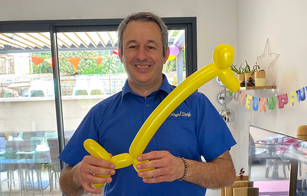 Photo du magicien Magic David avec un ballon en forme de girafe